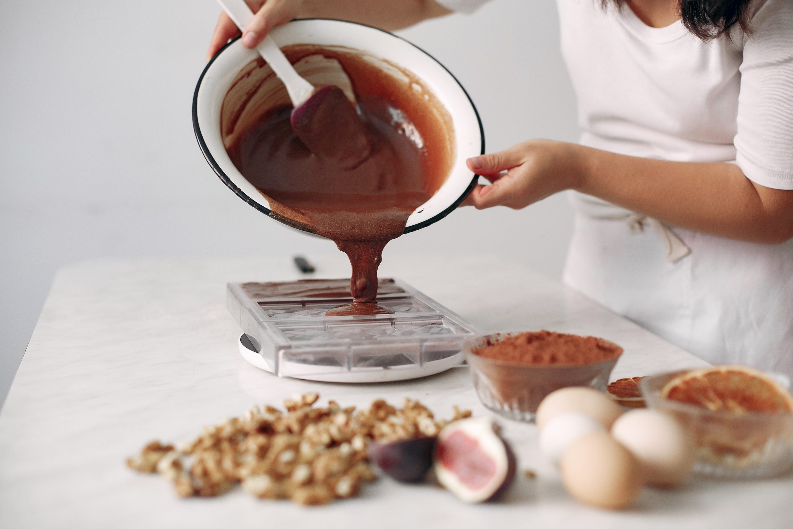 Chef in white clothes prepares a chocolate cake